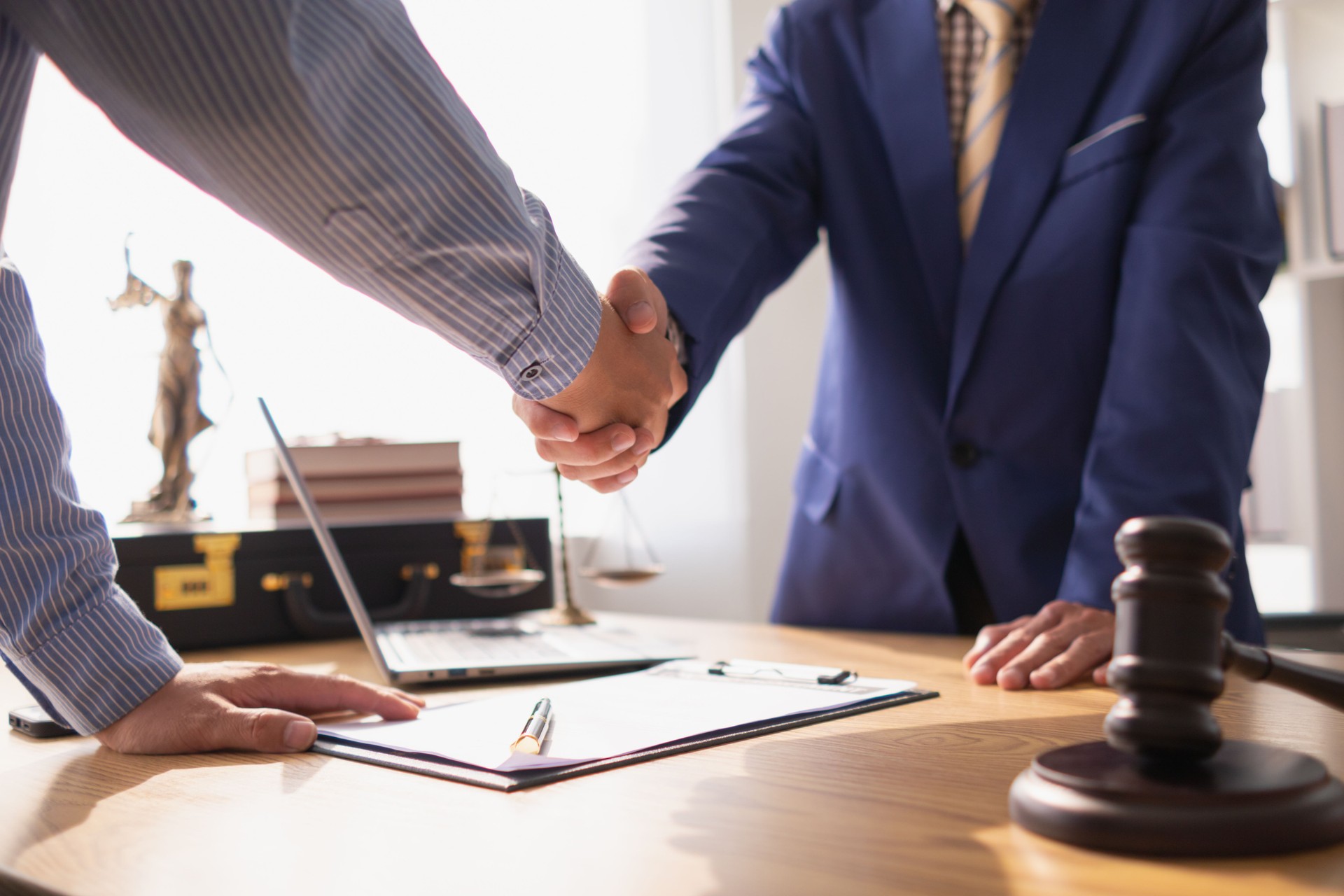 Businessmen and investors discussed joint venture within the legal counsel office and agreed to sign a contract in front of the lawyers within the legal counsel office to witness the joint investment.